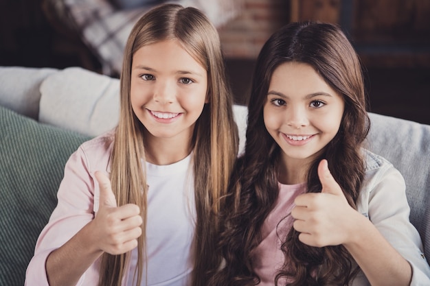 Little sisters posing on the couch together