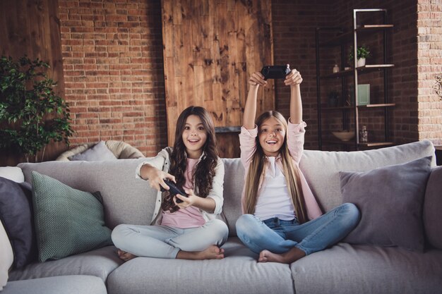 Little sisters posing on the couch together