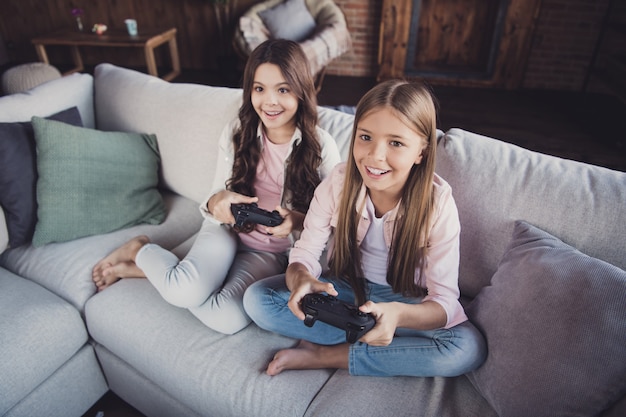 Little sisters posing on the couch together