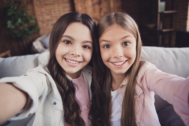 Little sisters posing together on the couch