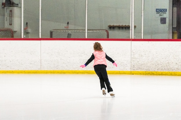 Photo little skater practicing her elements at the morning figure skating practice