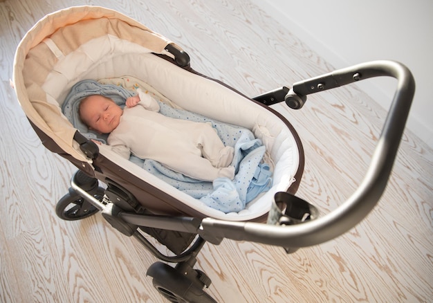 A little sleeping newborn baby lying in the pram