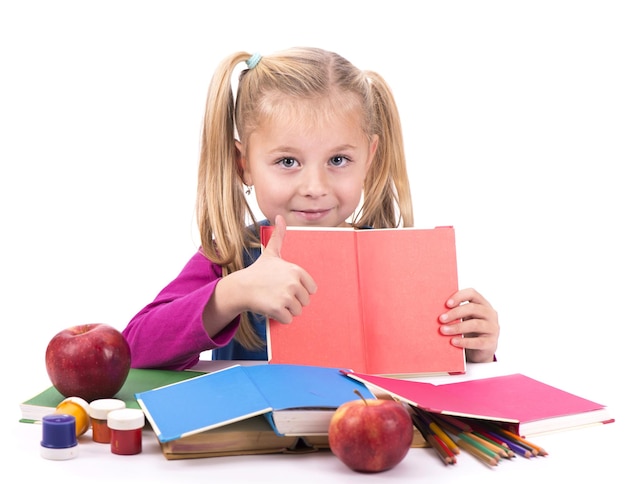 Little smart girl holding a book and reading it on a white background