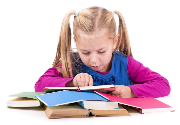 Little smart girl holding a book and reading it on a white background