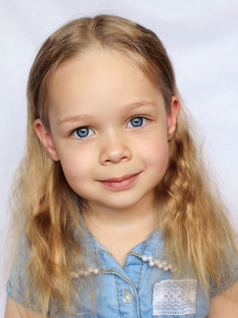 Little smiling blue-eyed beautiful baby girl, on a white background