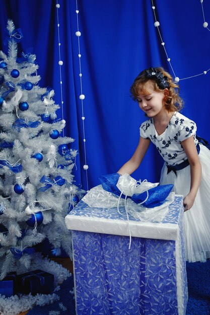 Little smiling girl with a big gift box.