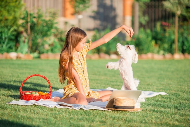 Little smiling girl with her dog in the park