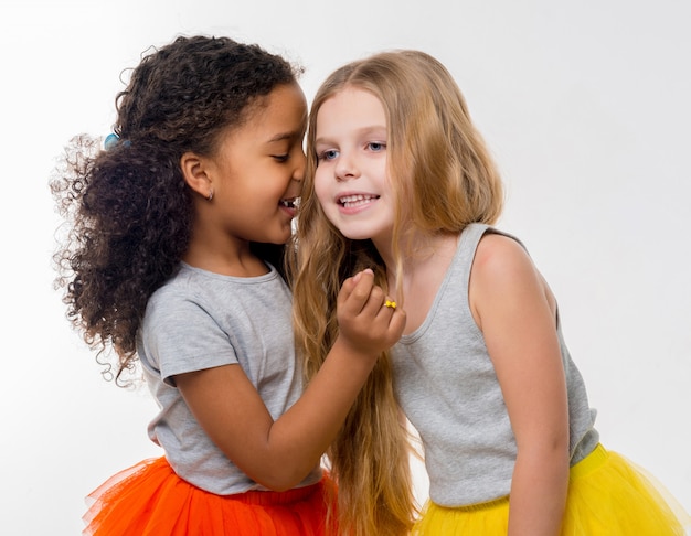 Photo little smiling girls gossiping