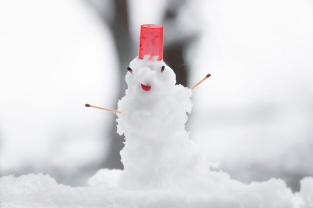 Little snowman on the window cold winter day after snowfall