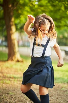 Piccola scolaretta spagnola che balla nel parco