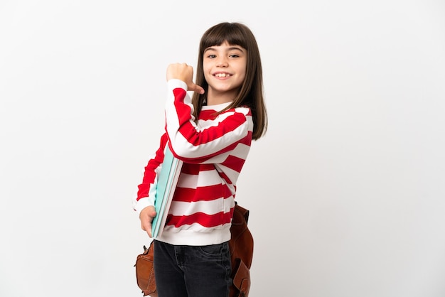 Little student girl isolated on white wall proud and self-satisfied