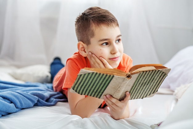 Little student reading a book. 