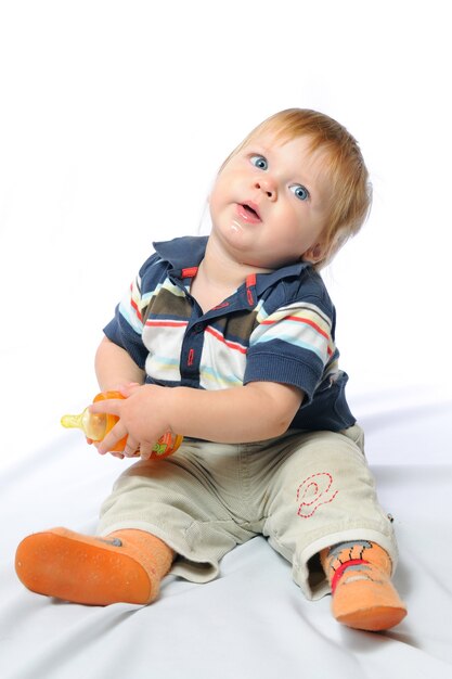 Little toddler with orange bottle