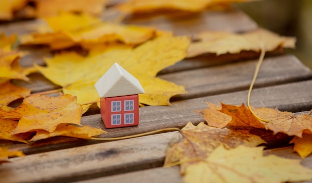 テーブルの上の紅葉の横にある小さなおもちゃの家