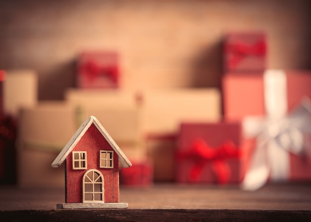 Little toy house and Christmas gifts on background