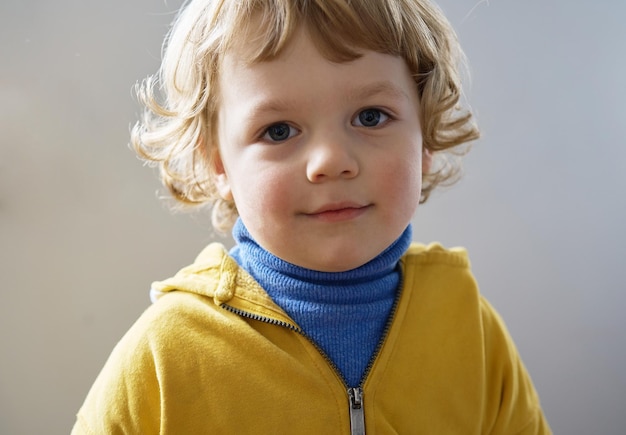 Piccolo bambino ucraino indossa abiti blu e gialli