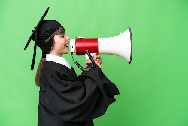 Little university girl over isolated background shouting through a megaphone