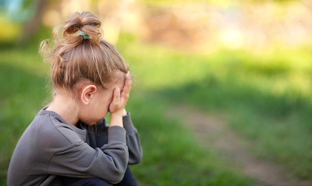 the little upset girl pressed her hands to her face