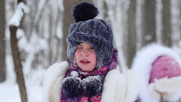 A little upset girl with snow on her face