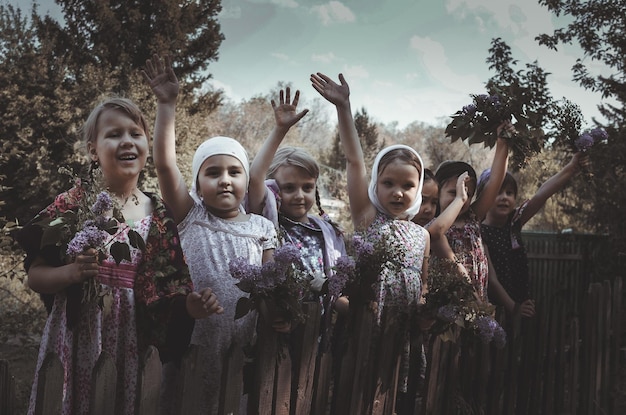 little village girls of different nationalities accompany people to war at the old wooden fence