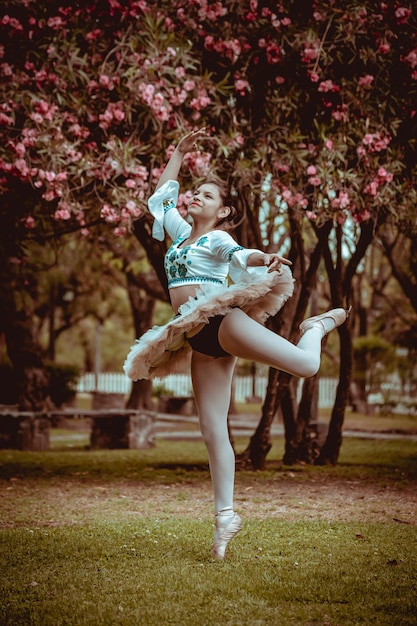 little woman dancing ballet with her dress in natur