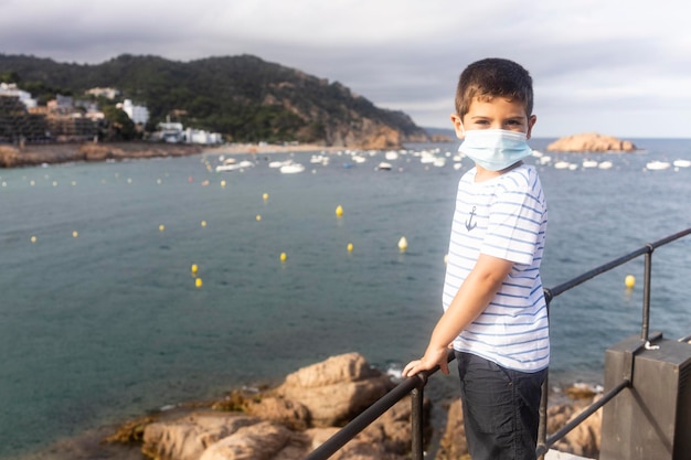 Foto un ragazzino con una maschera che guarda il mare su un villaggio di pescatori.