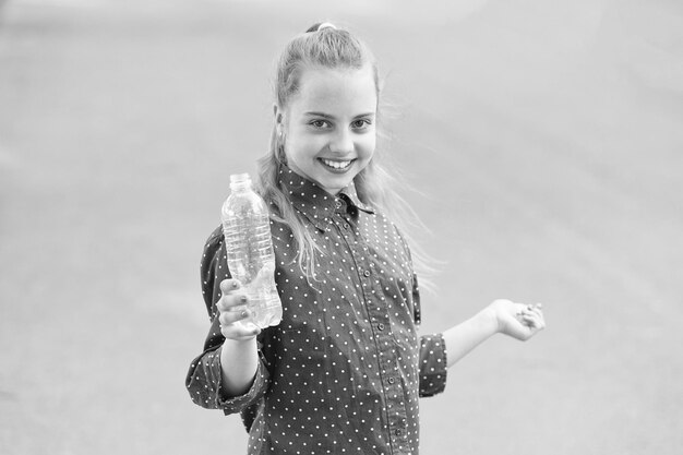 Live healthy life Healthy and hydrated Girl care about health and water balance Girl cute cheerful hold water bottle Water balance concept Drink water during summer walk Make one more sip