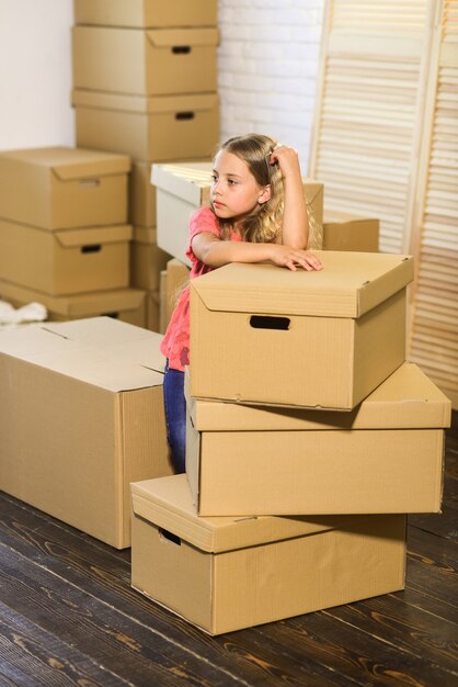 Live outside the lines. moving concept. new apartment. purchase\
of new habitation. cardboard boxes - moving to new house. happy\
child cardboard box. happy little girl.