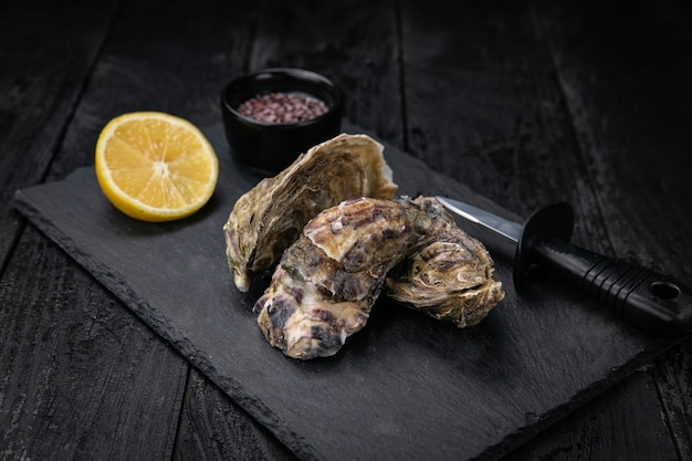 live oysters with sauce on a dark background