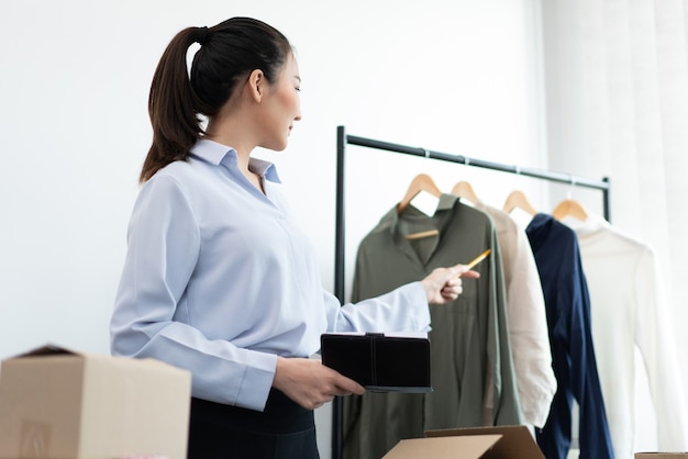 Live shopping concept a female seller broadcasting a livestream selling working long-sleeved shirts on social media.