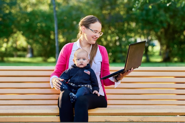 Live streaming lessen met laptop door vrouw met baby buiten