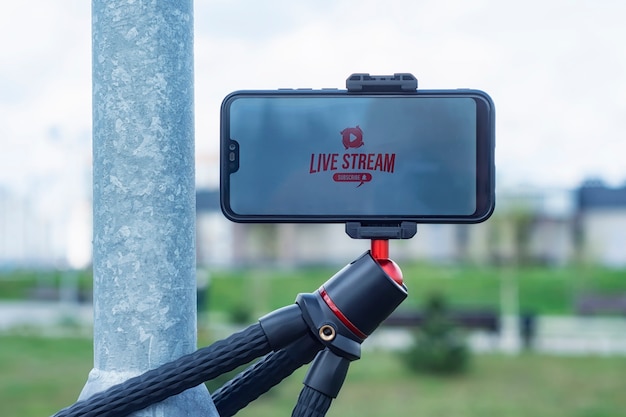 Live Strream and subscribe to Internet channel on the smartphone display on a flexible tripod. Outdoor travel equipment.