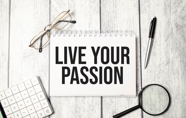 LIVE YOUR PASSION text on notepad with glasses pen and calculator