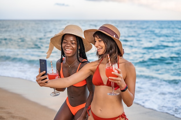 Lively diverse women taking self portrait on beach