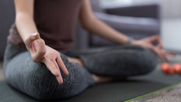 Una ragazza vivace che fa meditare per mantenere la mente calma ed essere rilassata come la sua attività indoor.