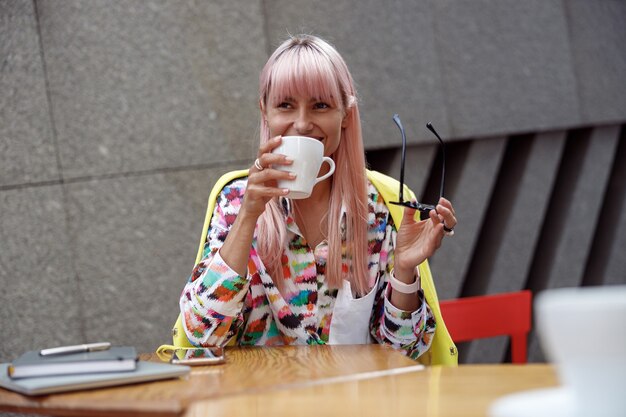 Lively woman bringing cup of coffee to her mouth