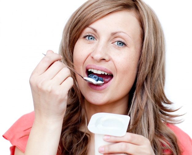 Lively woman eating a yogurt 