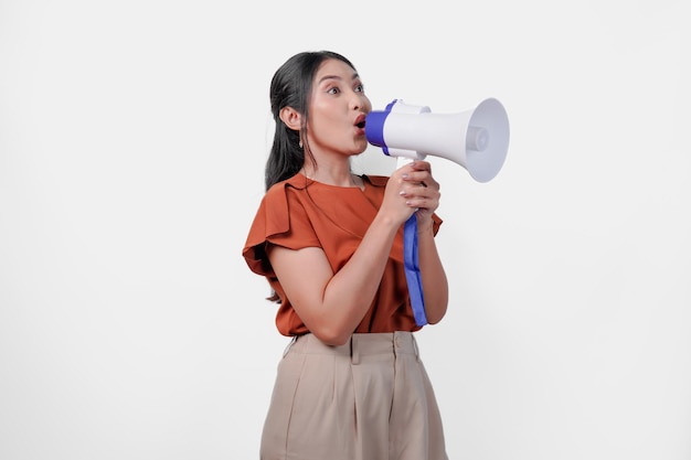 Lively young Asian woman shouting at megaphone as if the woman is performing or giving a speech