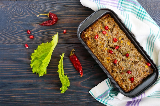 Liver casserole. Useful dish from the liver. Freshly baked pork liver souffle with rice and vegetables on a wooden table. Top view.