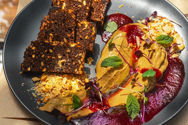 Liver pate and croutons on a black plate with serving Close up