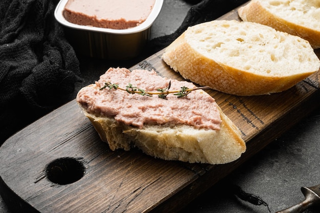 Patè di fegato sul set di pane tostato, su sfondo di tavolo in pietra scura nera