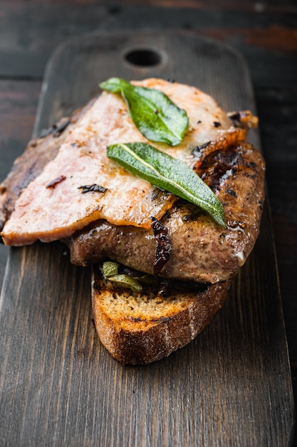 Liver with bacon and onions on a wooden board