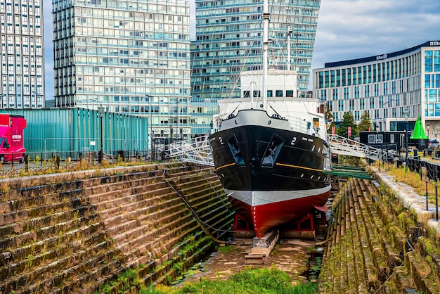 Liverpool, England. September 30, 2021. Modern city buildings and sailing nautical vessel moored at dock