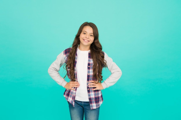 Living happy life Good mood concept Positive vibes Sincere emotions Cute girl with long hair Little girl turquoise background Small girl checkered shirt Happy international childrens day