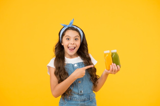 Living healthy life Vitamin juice Fresh smoothie Girl drinking orange fresh smoothie Vegetarian concept Smiling kid hold fruit smoothie bottles Healthy food Buy food Supermarket promotion