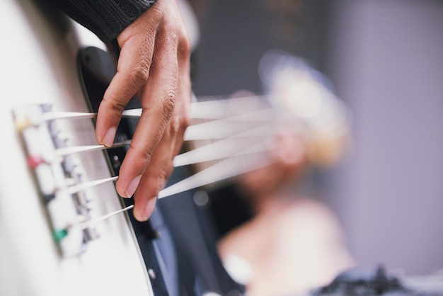 Living a life full of music. Cropped shot of an unrecognisable man playing the guitar in a music studio during the day.