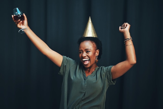 Living my best life Cropped shot of an attractive young woman dancing alone against a dark background at a New Years party