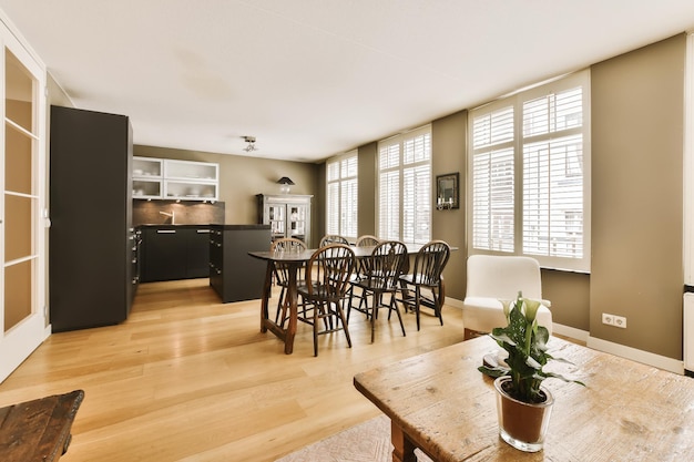 Foto un soggiorno e una sala da pranzo in un appartamento residenziale con pavimenti in legno finestre a persiane bianche pavimentazione in legno duro