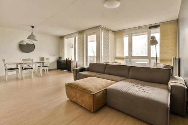 A living room and dining room with a brown couch