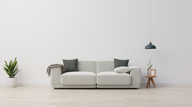 Living room interior wall with gray velvet sofa, gray pillows, plaid and green plant branch in vase on empty white wall background.